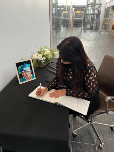 Natasha Asghar MS writing in a book of condolences.