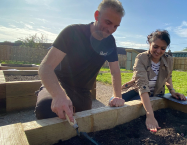 Natasha helps Toby from United Response plant bulbs 